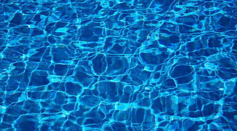 bunte gefilzte Kugeln sind zu sehen blaues wasser