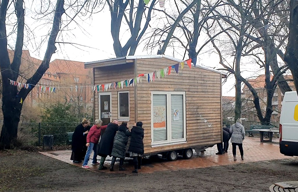 Kolleginnen und Besucherinnen beim Positionieren des TinyHauses